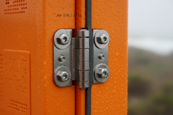 Close-up 316L stainless steel hinge with water droplets on rugged SIP phone enclosure