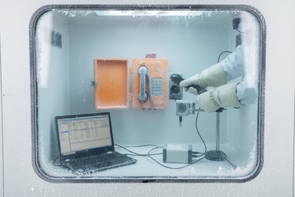 Environmental chamber test of waterproof SIP phone with technician tools and monitoring laptop