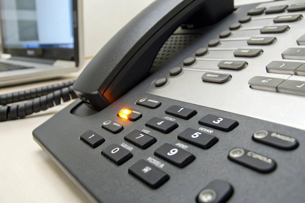 Closeup of enterprise IP desk phone with voicemail indicator light on