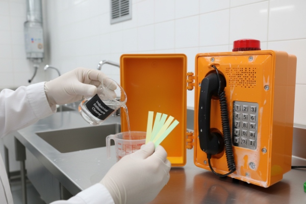 Chemical solution poured while pH strips test orange SIP emergency phone housing resistance