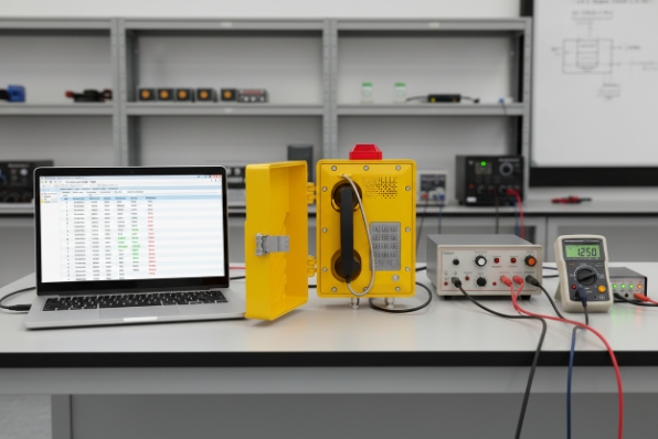 Lab test bench with laptop and instruments connected to explosion-proof industrial telephone