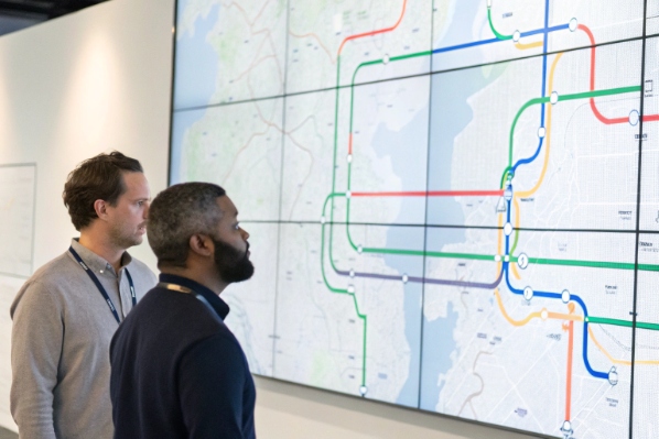 Transport control operators monitoring metro route map on video wall