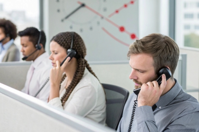 Inbound call center agents handling customer support calls on phones and headsets