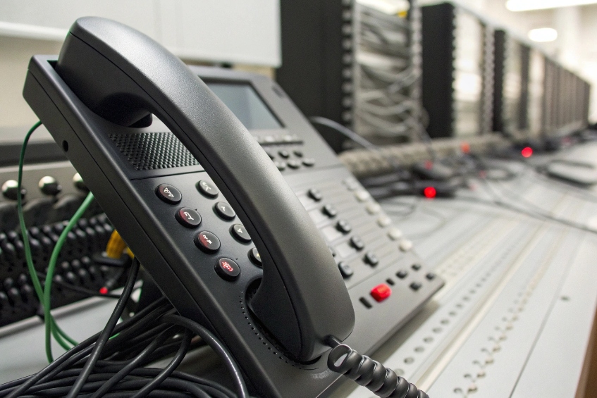 VoIP test bench with multiple SIP phones wired to telecom equipment